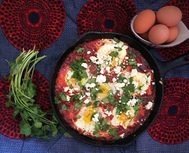 Shashuka-breakfast filled with vine ripened tomatoes, eggs, cheese and fresh herbs.